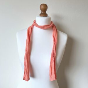 Peach skinny scarf made of softened linen fabric, displayed on a white mannequin. The scarf is thin, with a simple design