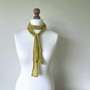 Yellow green skinny linen scarf styled on a white mannequin to show 10 cm width and drape.