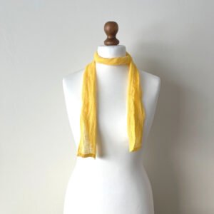 A skinny yellow scarf handmade of lightweight gauze linen fabric. All edges are plain hemmed.
