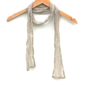A skinny natural flax scarf hanging on a wooden hanger. The scarf is thin, with a simple design.