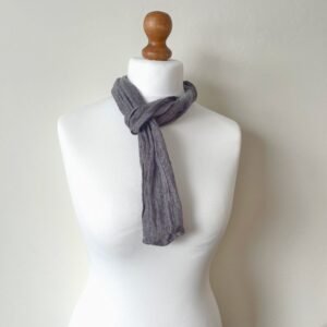 A handmade skinny greyish purple open-weave unisex linen scarf styled on white mannequin, showing its length and fit.